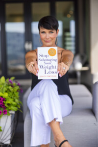 Jennifer Powter holding her book Stop Sabotaging Your Weight Loss